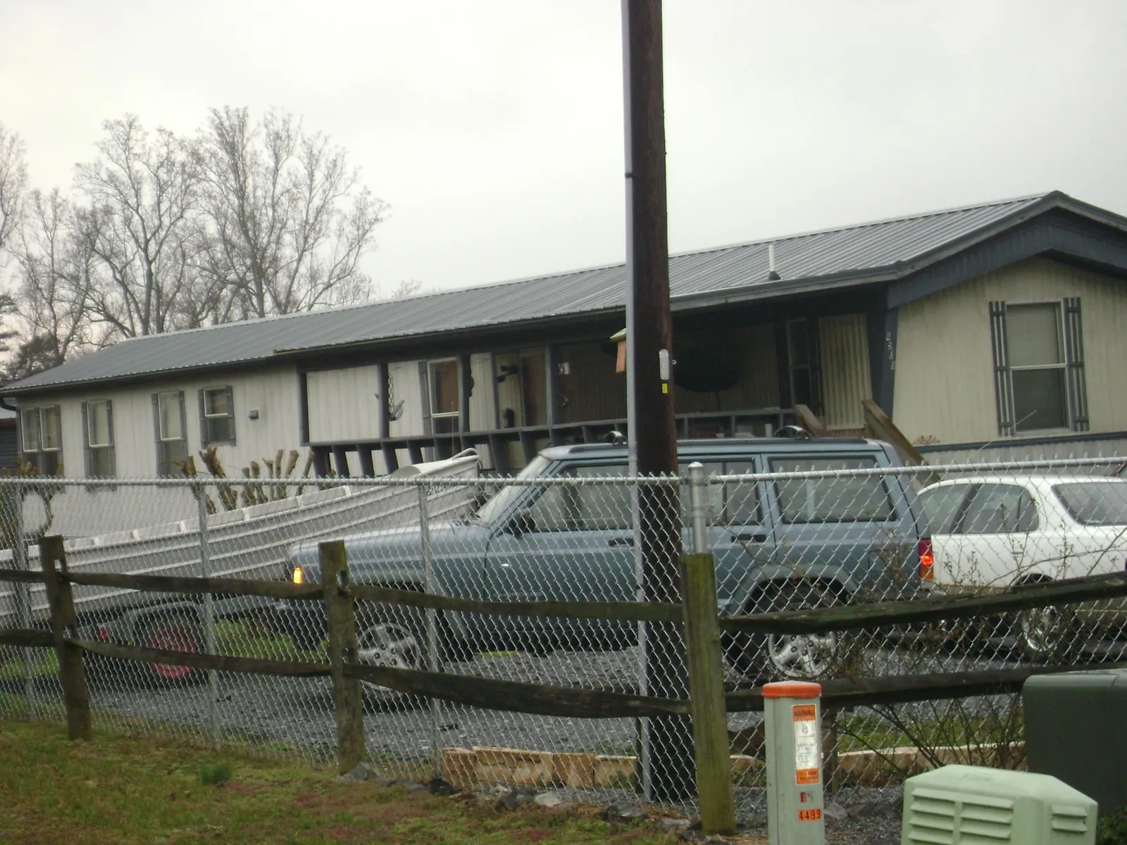 Dark metal roof on a long single story building behind a chain link fence in Mission Viejo