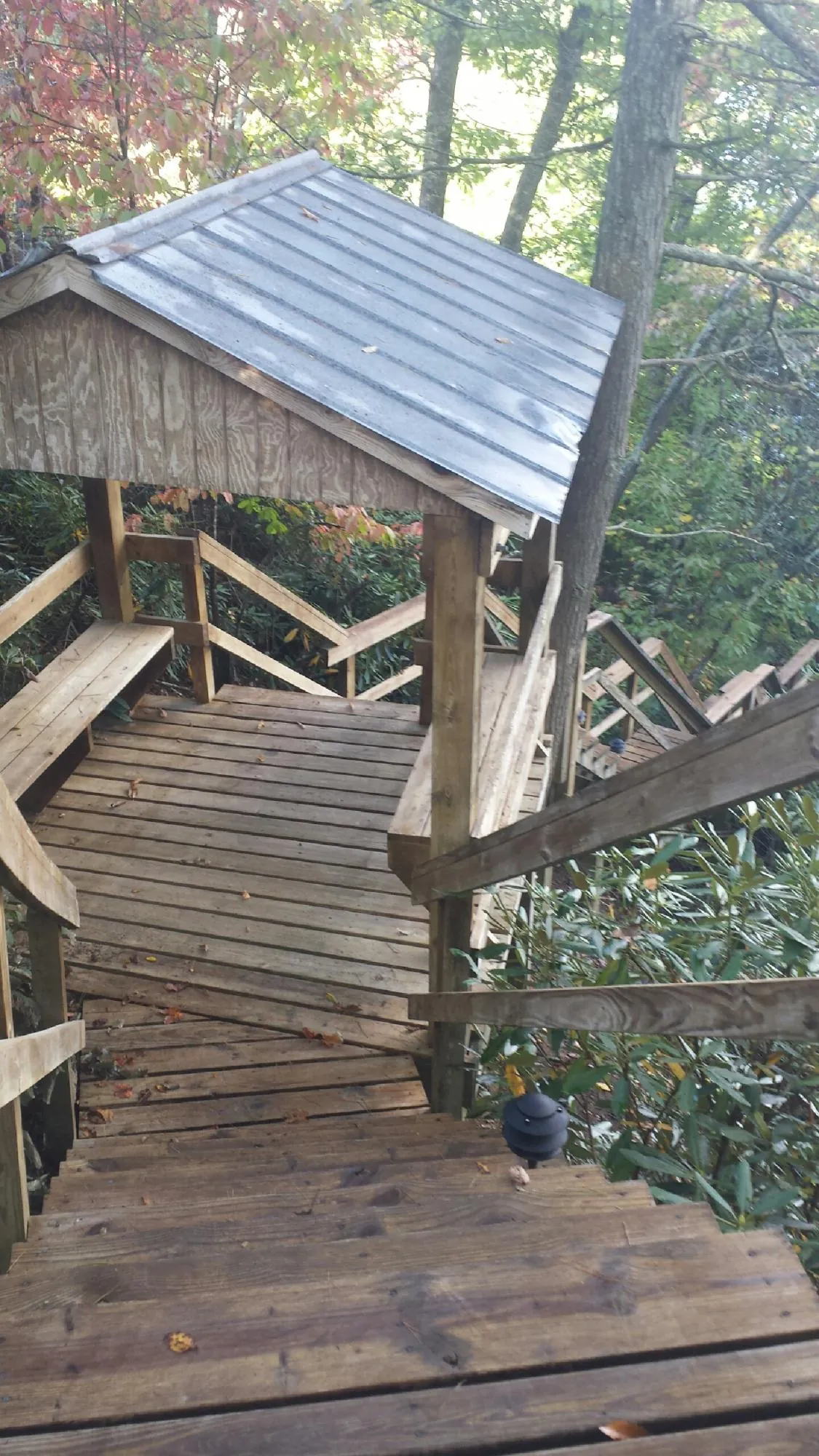 Metal roofed shelter over wooden steps on a wooded walkway — Skylight Repair & Installation work by our crew in Mission Viejo